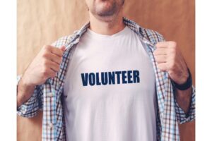 learn a new skill: a man wearing a shirt that says volunteer