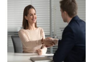 woman shaking hands with a man after getting employed